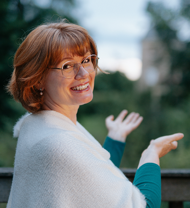 Frau mit Buch, schaut aus dem Fenster